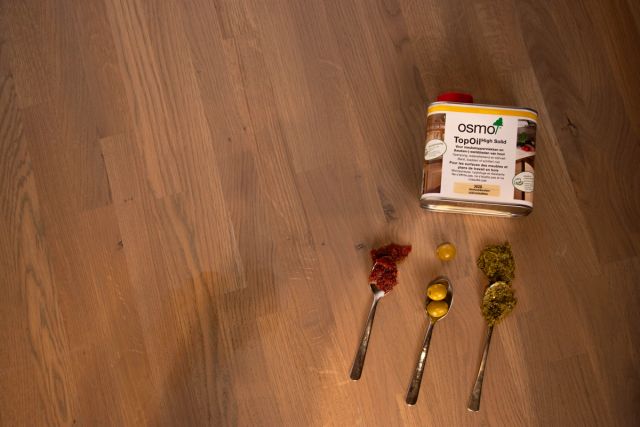 Houten tafelblad met vlekken en een Osmo-onderhoudsproduct