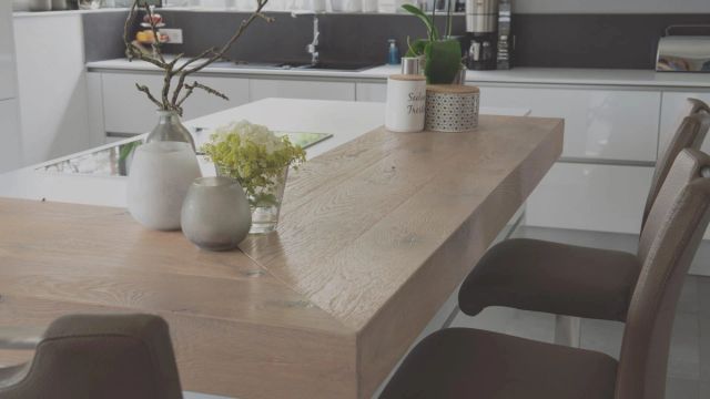 Lichte houten bartafel in een keuken met planten