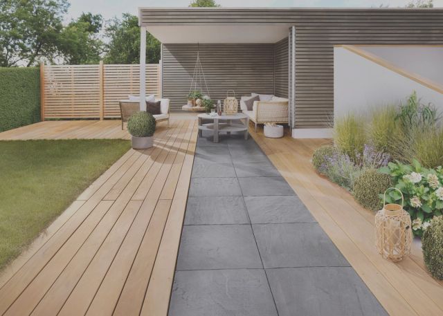 Houten vlonderpad langs een overkapping in de tuin