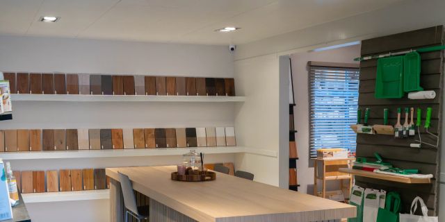 Osmo-showroom met kleurstalen aan de wand en een houten tafel