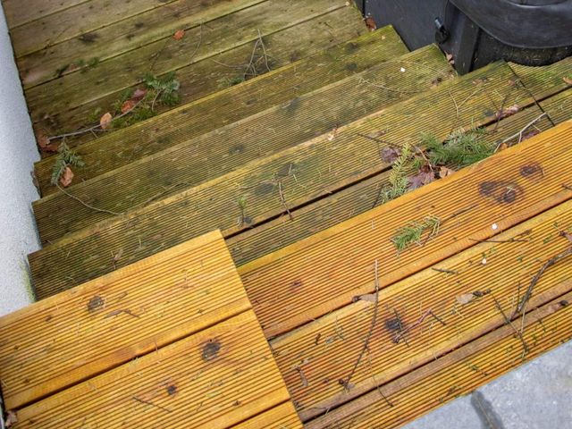 Houten vlonder half gereinigd, met groene aanslag nog zichtbaar