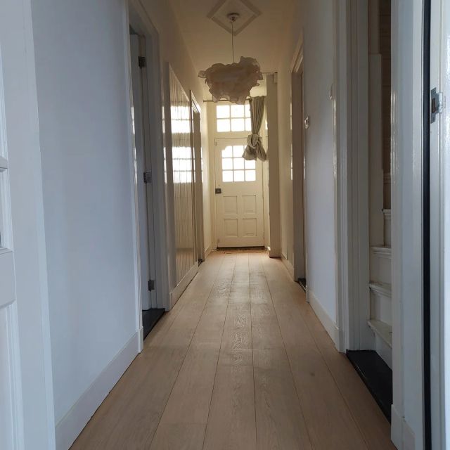 Eiken vloer in een lange gang met witte deuren, behandeld met Osmo Hardwax-Olie Effect 3041, Natural