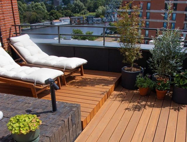 Dakterras met houten vlonder, ligbed en planten