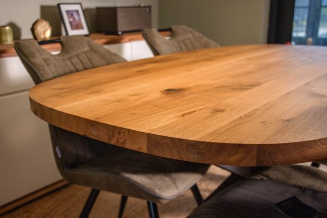 Ovale eikenhouten tafel met stoelen in een woonkamer