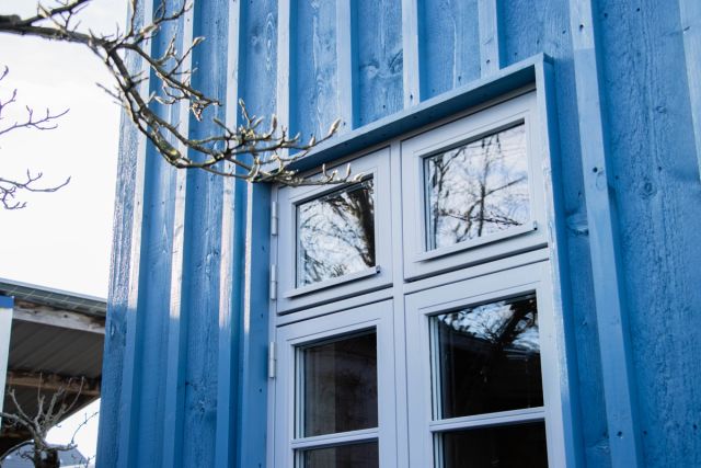 Blauw geschilderd buitenkozijn met wit raam