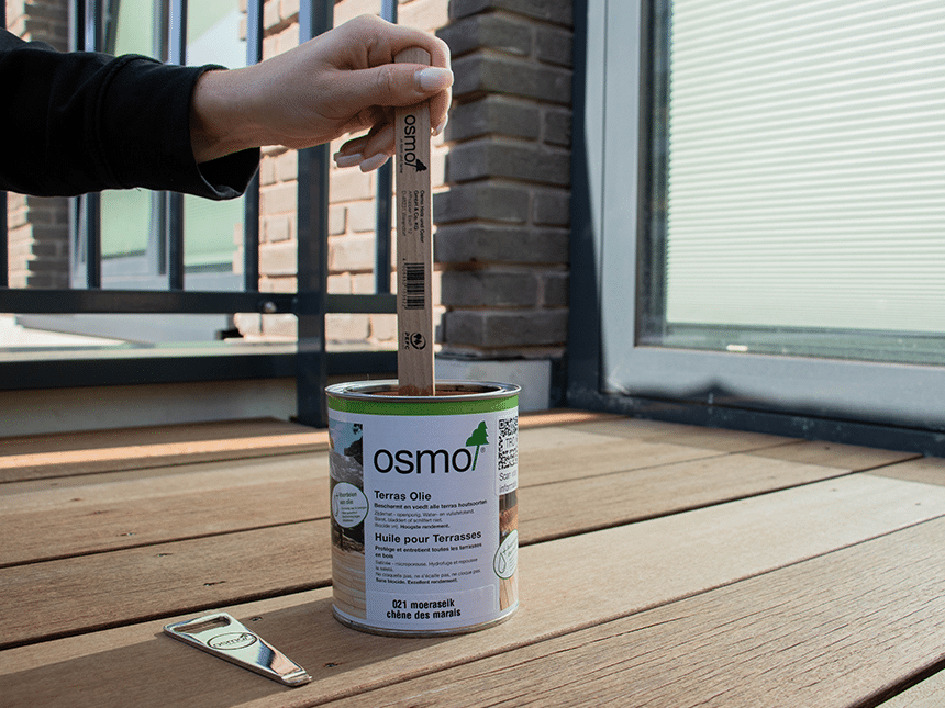 Persoon dipt stokje in de verf.