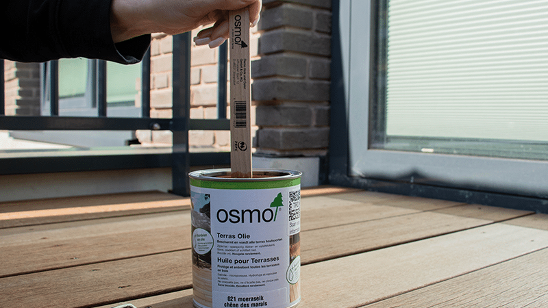 Persoon dipt stokje in de verf.