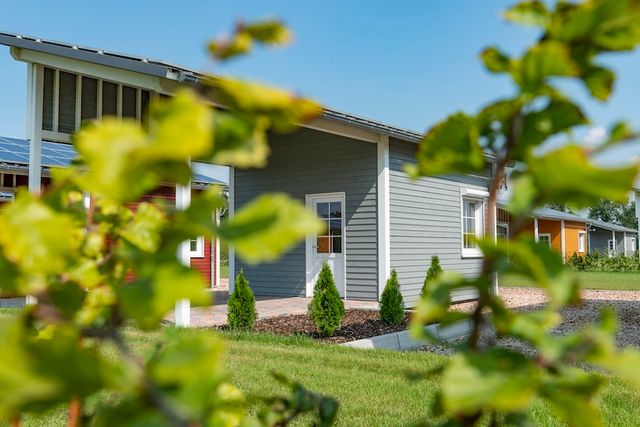 Grijs geverfde woning, gezien door gele herfstbladeren