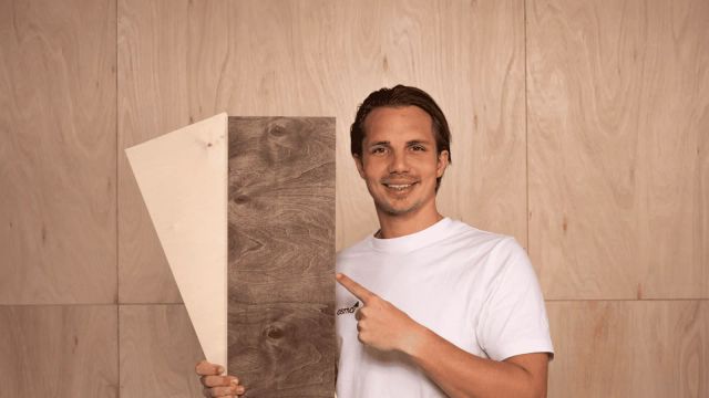 Man met multiplexplaten voor een wand van multiplex
