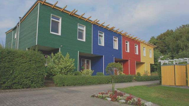 Rij woningen met groene, blauwe en rode houten gevels