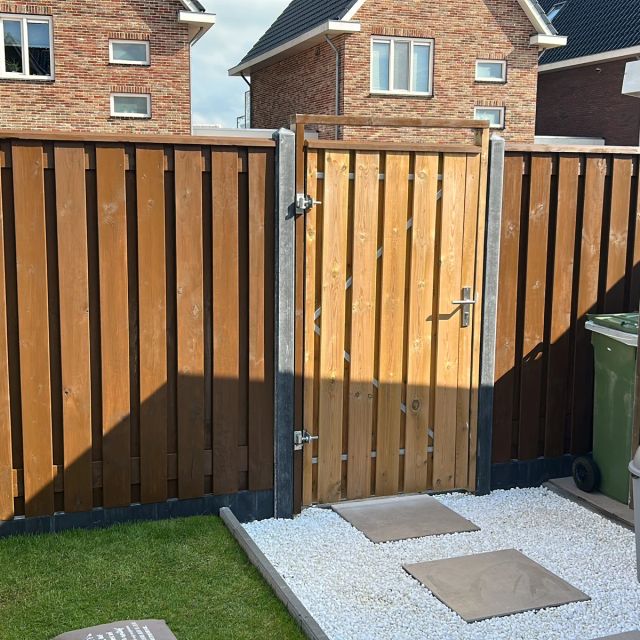 Douglas schutting met tuinpoort in een stadstuin, behandeld met Osmo Landhuisverf 2606, Middelbruin