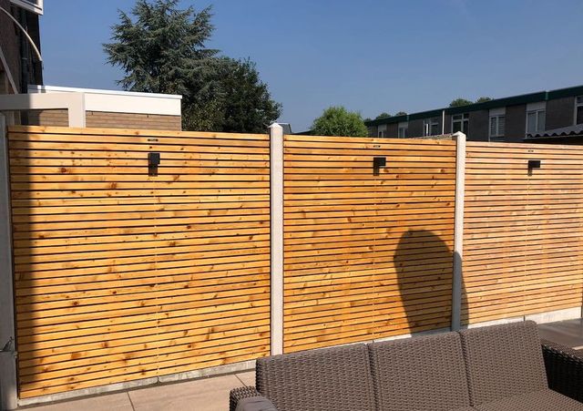 Geïmpregneerde houten schutting tussen betonnen palen