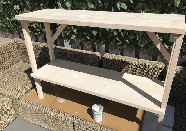 Onbehandelde steigerhouten sidetable buiten met een blik beits