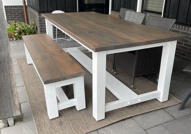 Houten tuintafel met wit onderstel op een terras