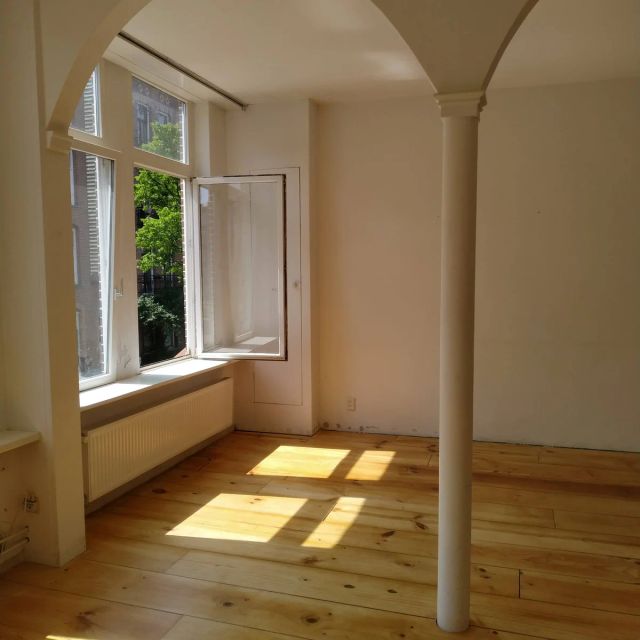 Grenen vloer met zonlicht en witte zuil onder een boog, behandeld met Osmo Hardwaxolie Original 3065, Kleurloos semi-mat