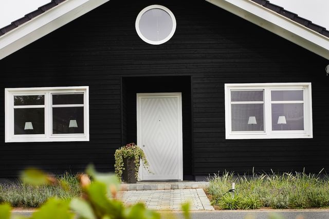 Zwart geverfd huis met Zweeds rabat en witte kozijnen