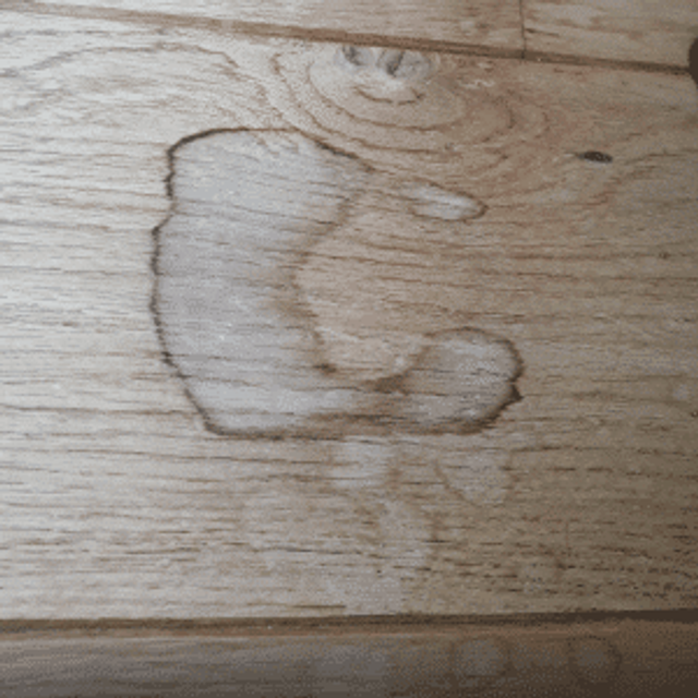 Close-up van een vlek op een licht houten vloer