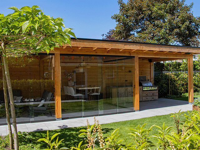 Houten overkapping in een tuin met loungeset