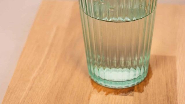 Wooden table with a glass of water