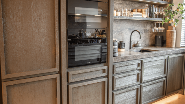 Keuken met houten kastjes en een zwarte oven