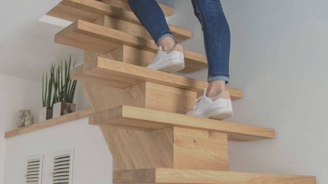 Persoon loopt een lichte houten trap op