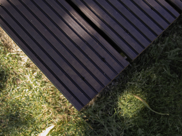 Bovenaanzicht van een donker geverfd grenen tuinmeubel in het gras