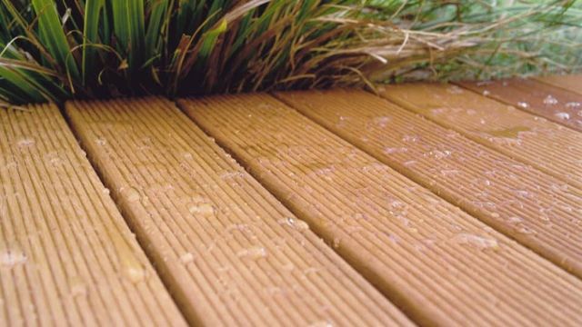 Natte bankirai terrasplanken met siergras
