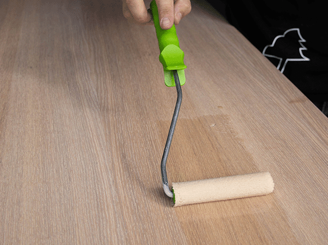 Persoon brengt olie aan op hout.