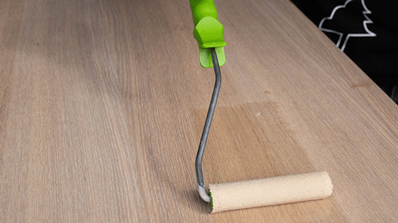 Persoon brengt olie aan op hout.