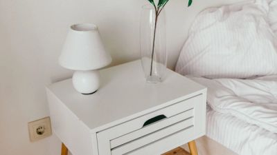 Wit kastje met bed en houten vloer.