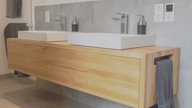 Badkamer met een houten wastafelmeubel en witte wasbak