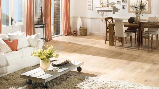 Woonkamer met lichte parketvloer, witte bank en eettafel