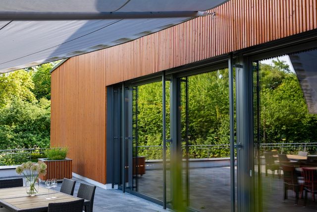 Moderne woning met houten gevelbekleding en grote glazen pui