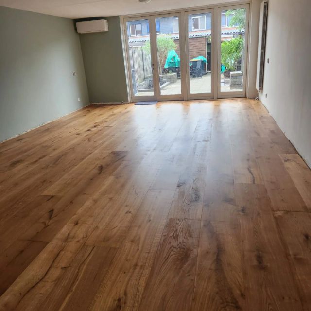 Eiken vloer in een lange woonkamer met tuindeuren, behandeld met Osmo Hardwaxolie Original 3065, Kleurloos semi-mat