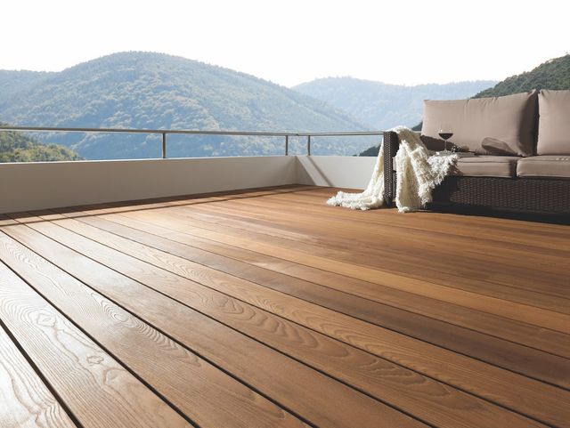 Houten vlonder met loungeset en uitzicht op de bergen