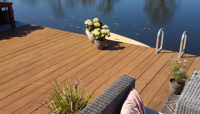 Douglas fir decking by the water with a lounge set