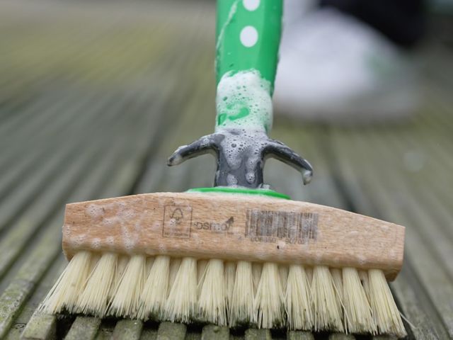 Close-up van een schrobborstel op een houten terras
