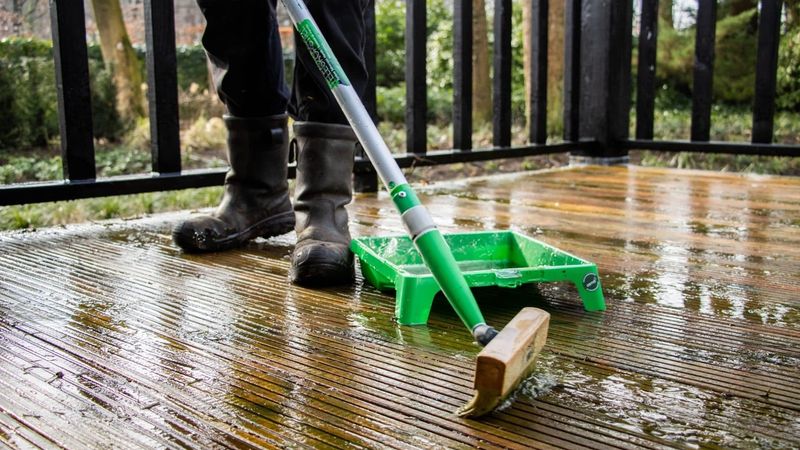Person is coating the decking