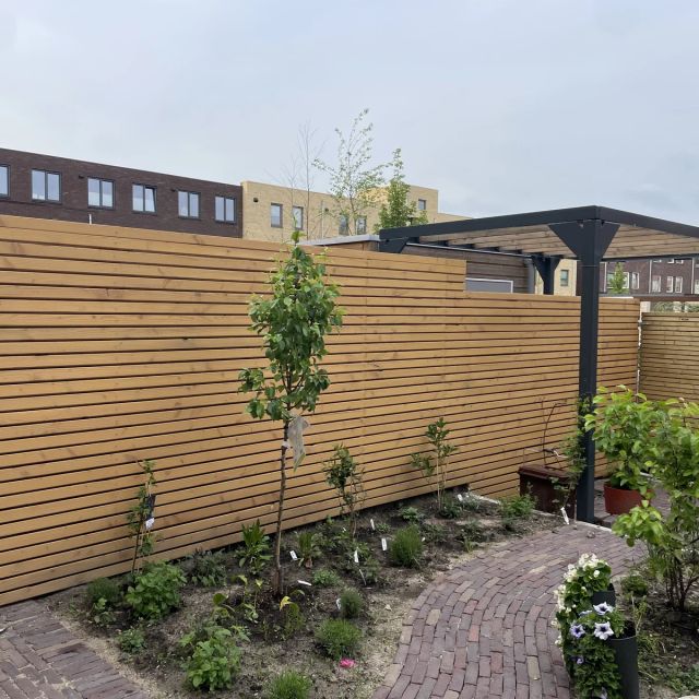 Horizontale douglas lattenschutting in een nieuwe tuin, behandeld met Osmo Natuurlijke Olie-Beits 710, Pijnboom