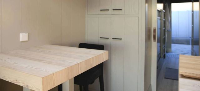 Lichte houten keukentafel in een keuken met witte kasten