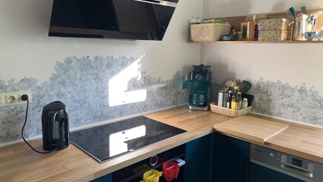 Keuken met een licht houten aanrechtblad en zwarte kasten