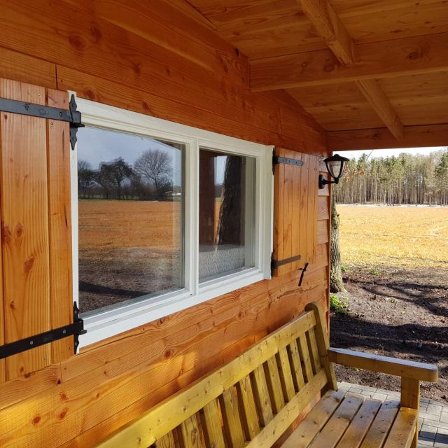 Douglas tuinhuis met houten luiken en veranda, behandeld met Osmo UV-Beschermingsolie 420, Kleurloos