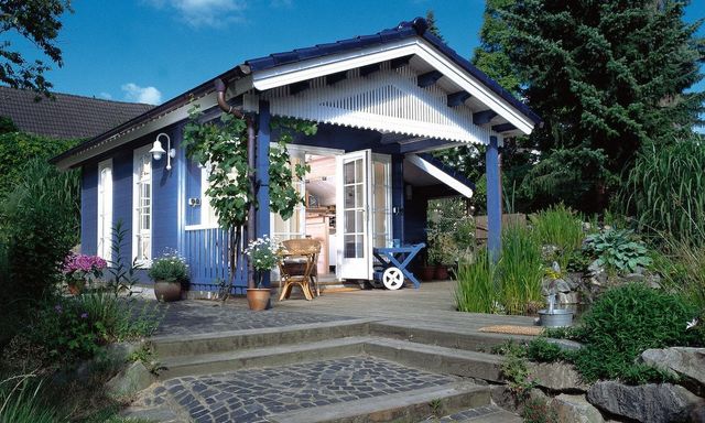 Blauw geverfd tuinhuis met veranda en tuin