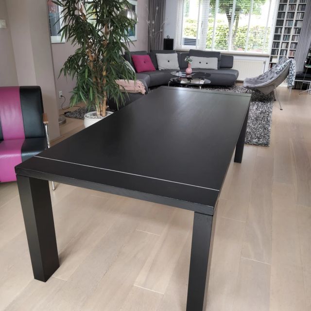 Zwarte eiken eettafel in een lichte woonkamer, behandeld met Osmo Olie-Beits 3590, Zwart