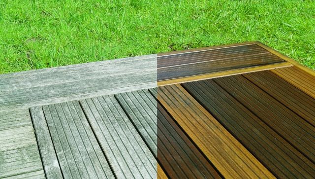 Houten vlonder deels ontgrijsd, met gras ernaast