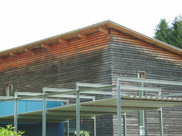 Moderne woning met grijze houten gevelbekleding en een zwembad
