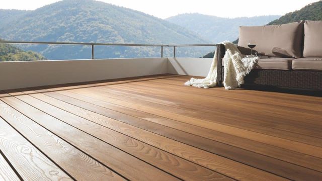 Houten vlonderterras met loungebank en uitzicht op bergen