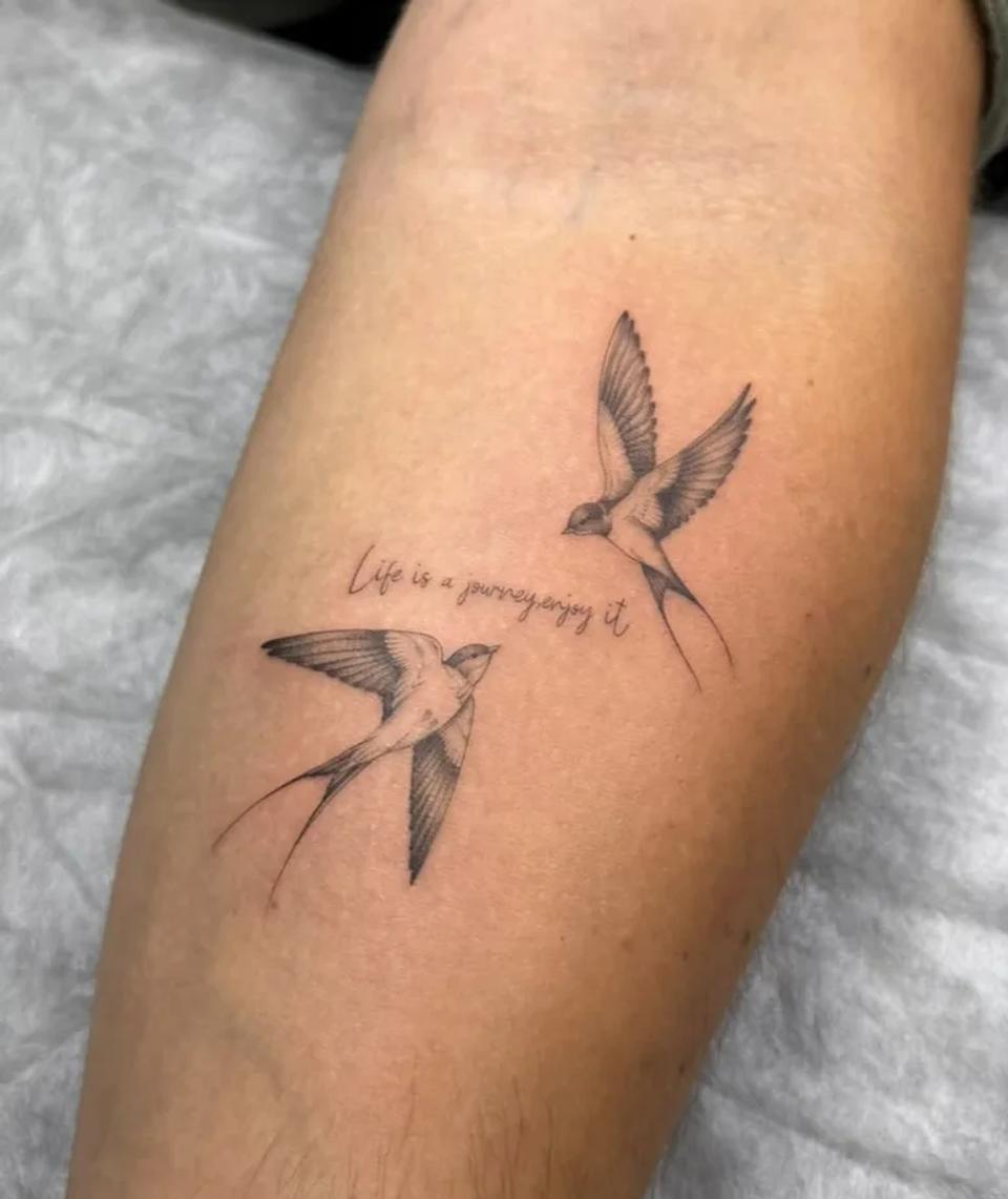 Fine line swallow birds forearm tattoo with elegant cursive script quote done at a professional tattoo shop in Budva.