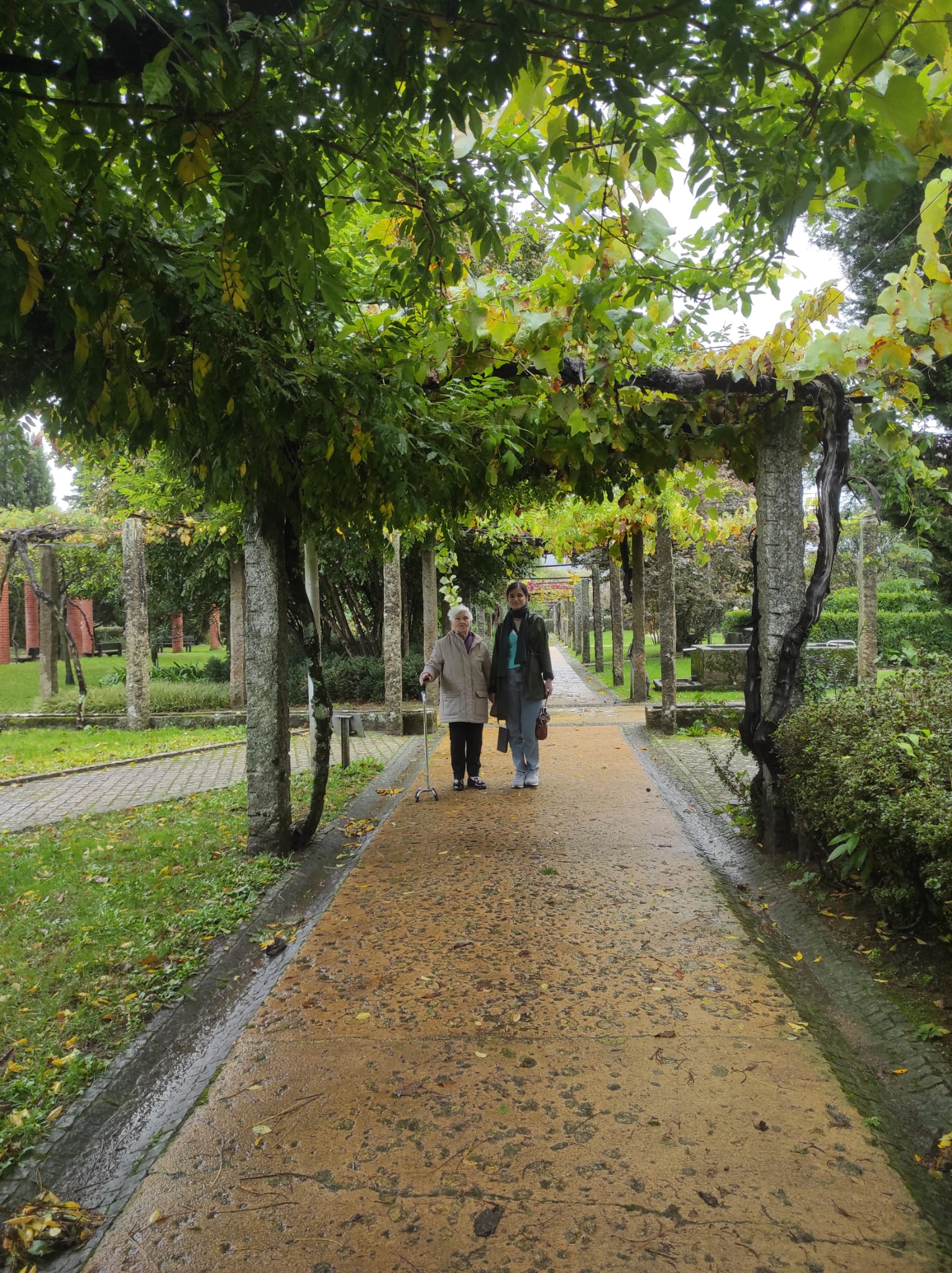 woman next to her grandmother in a garden on a rainy day