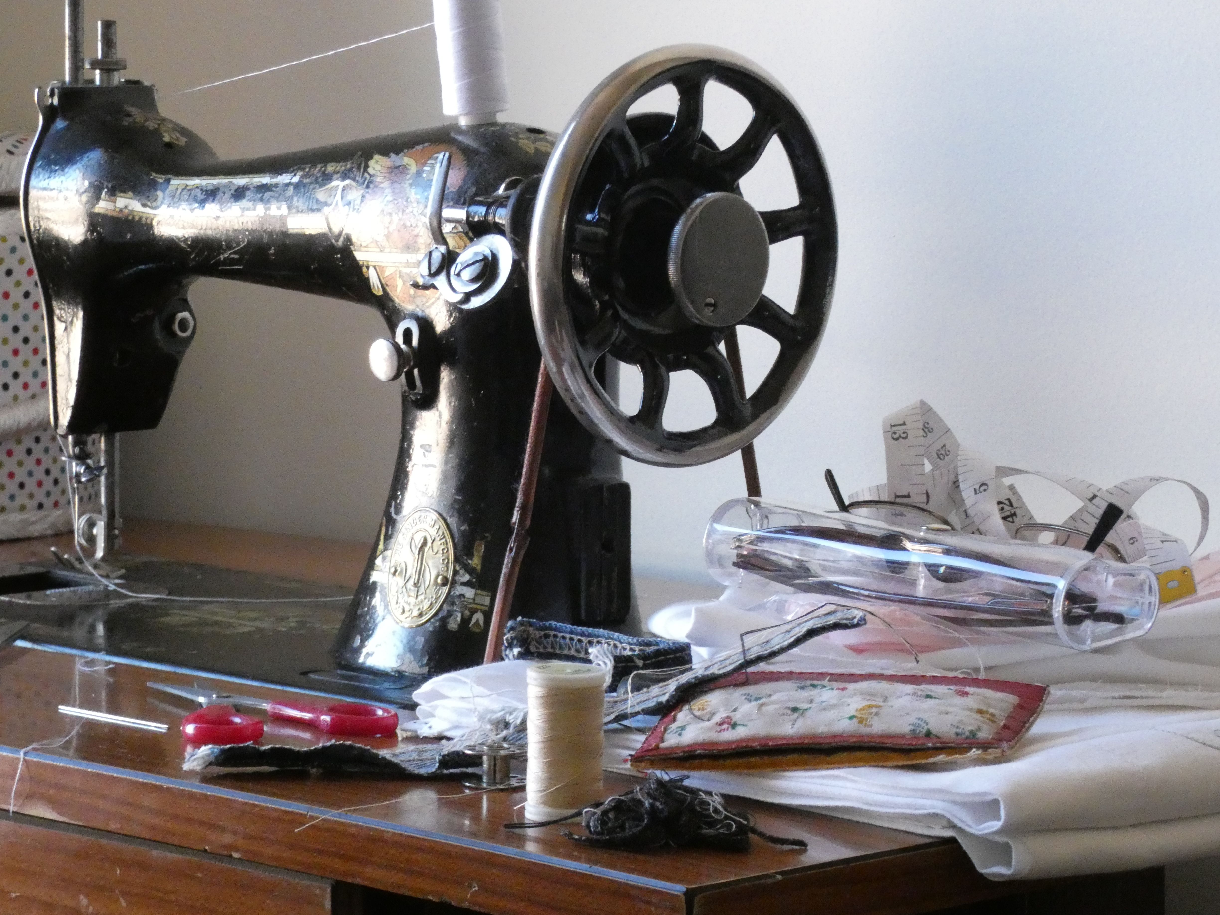 old sewing machine with other sewing tools next to it